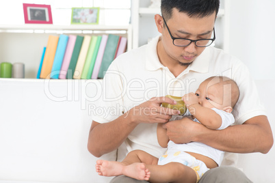 father bottle feeding baby