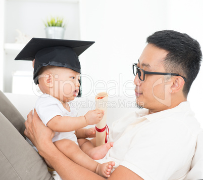 baby with graduation cap holding certificate