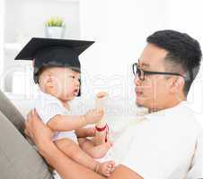 baby with graduation cap holding certificate