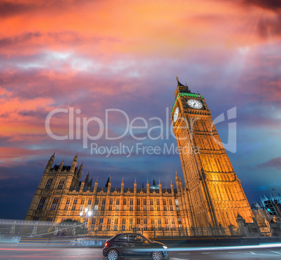 Westminster Palace and Big Ben after sunset, with small black ca
