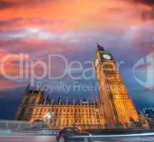 Westminster Palace and Big Ben after sunset, with small black ca
