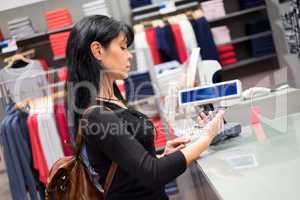 Mobile payment. Girl pays to shop using mobile phone