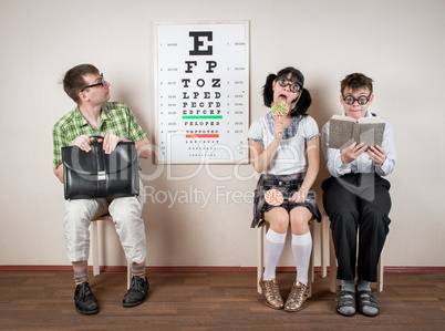 Three person wearing spectacles in an office at the doctor