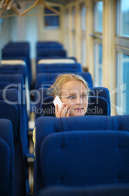 Woman sitting in a train talking on her mobile
