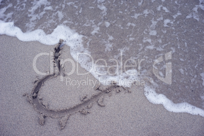 Heart drawn on the sand of the beach