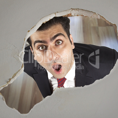 Man looking through a hole in the ceiling