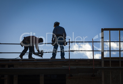 Construction Workers Silhouette on Roof