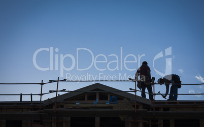 Construction Workers Silhouette on Roof