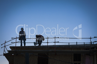 Construction Workers Silhouette on Roof