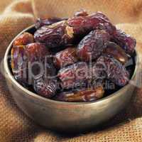 dates fruit in metal bowl.