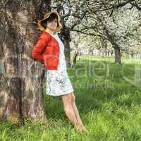 Woman with Straw Hat recovers under blooming cherry tree old