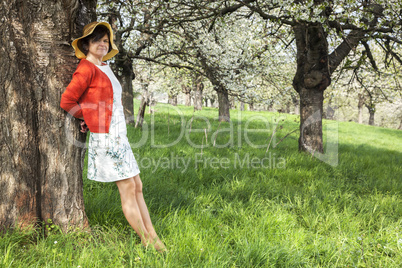 Woman with Straw Hat recovers under blooming cherry tree old