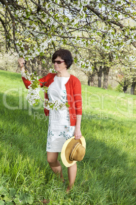 Woman with Straw Hat recovers under blooming cherry tree old