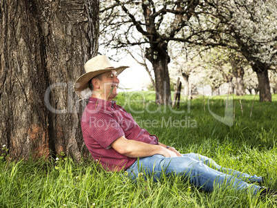 Man enjoys nature and is resting under the tree