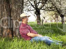 Man enjoys nature and is resting under the tree