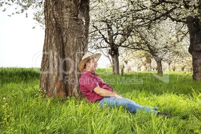 Man enjoys nature and is resting under the tree