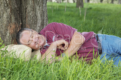 Tired man resting under the tree: