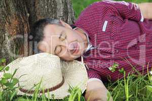 Tired man resting under the tree: