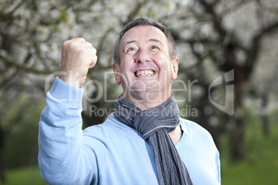 Friendly man in nature under blooming cherry tree