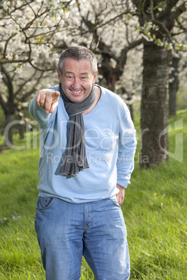 Man with hands under blooming cherry tree