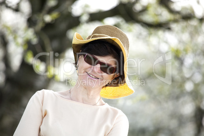 Women portrait with straw hat under blooming cherry tree old