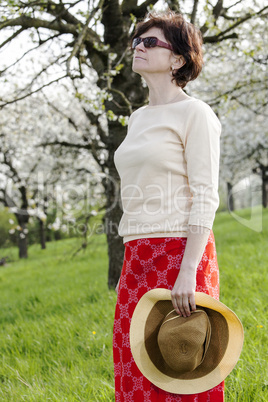Woman with straw hat with cherry blossom