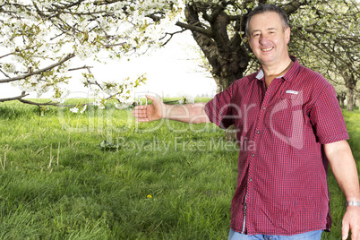 Man with hands under blooming cherry tree