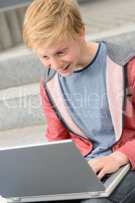 Surprised teenage student using laptop