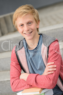 Smiling teenage student boy with books