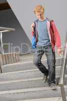 Student boy walking down university stairs