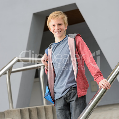 Teenage smiling student standing outside school