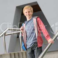 Teenage smiling student standing outside school