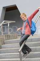 Student sliding down railing on stairway