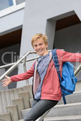 Excited student sliding down railing on stairway