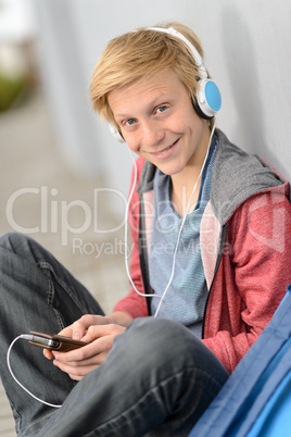 Happy teenage student listening to music