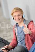 Happy teenage student thumb-up listen to music