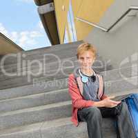 Confident student with tablet sitting on steps