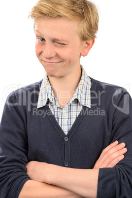 Playful boy winking while standing arms crossed