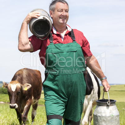 Farmer with milk jug with the cows