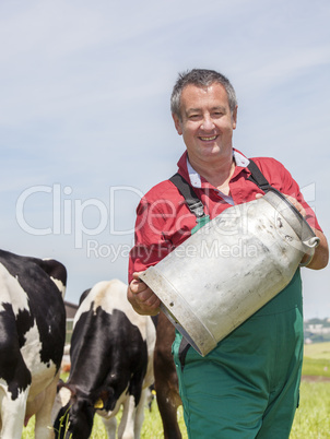 Farmer with milk jug with the cows