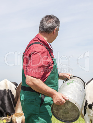 Farmer with milk jug with the cows