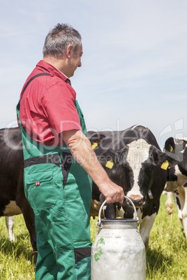 Farmer with milk jug with the cows