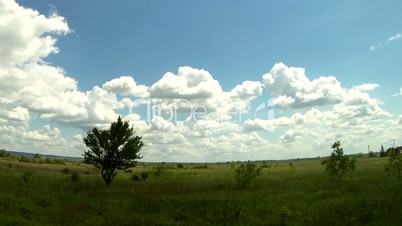Time lapse of clouds over a green field