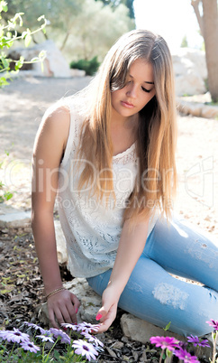 girl sat down near flower