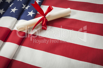 Ribbon Wrapped Diploma Resting on American Flag with Copy Space