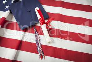 Graduation Cap and Diploma Resting on American Flag