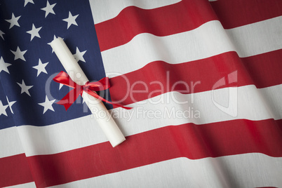 Ribbon Wrapped Diploma Resting on American Flag with Copy Space