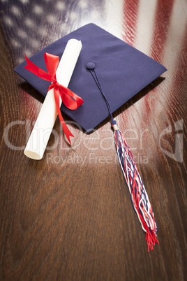 Graduation Cap and Dipoma on Table with American Flag Reflection