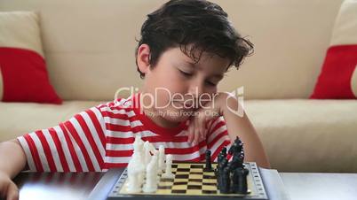 Little boy learning how to play chess