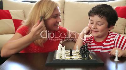 Mother teaches son how to play chess